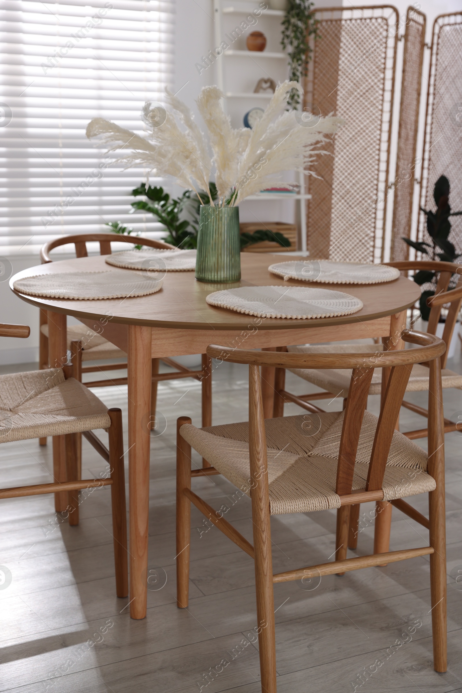 Photo of Stylish wooden table with chairs and decor indoors. Interior design