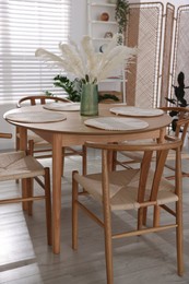 Photo of Stylish wooden table with chairs and decor indoors. Interior design