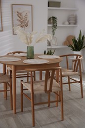 Photo of Stylish wooden table with chairs and decor indoors. Interior design