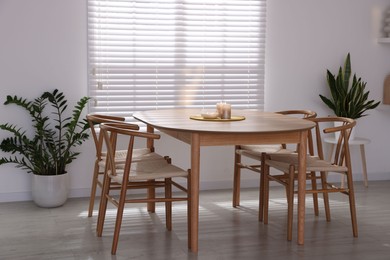 Photo of Stylish wooden table with chairs and decor indoors. Interior design