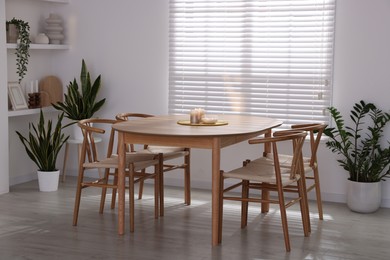 Photo of Stylish wooden table with chairs and decor indoors. Interior design