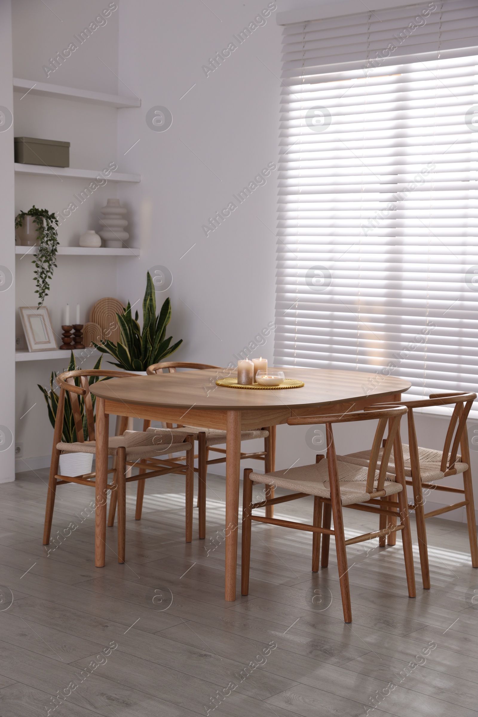 Photo of Stylish wooden table with chairs and decor indoors. Interior design