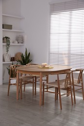 Photo of Stylish wooden table with chairs and decor indoors. Interior design