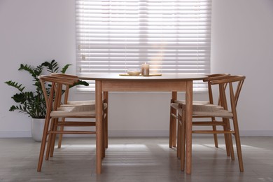 Photo of Stylish wooden table with chairs and decor indoors. Interior design