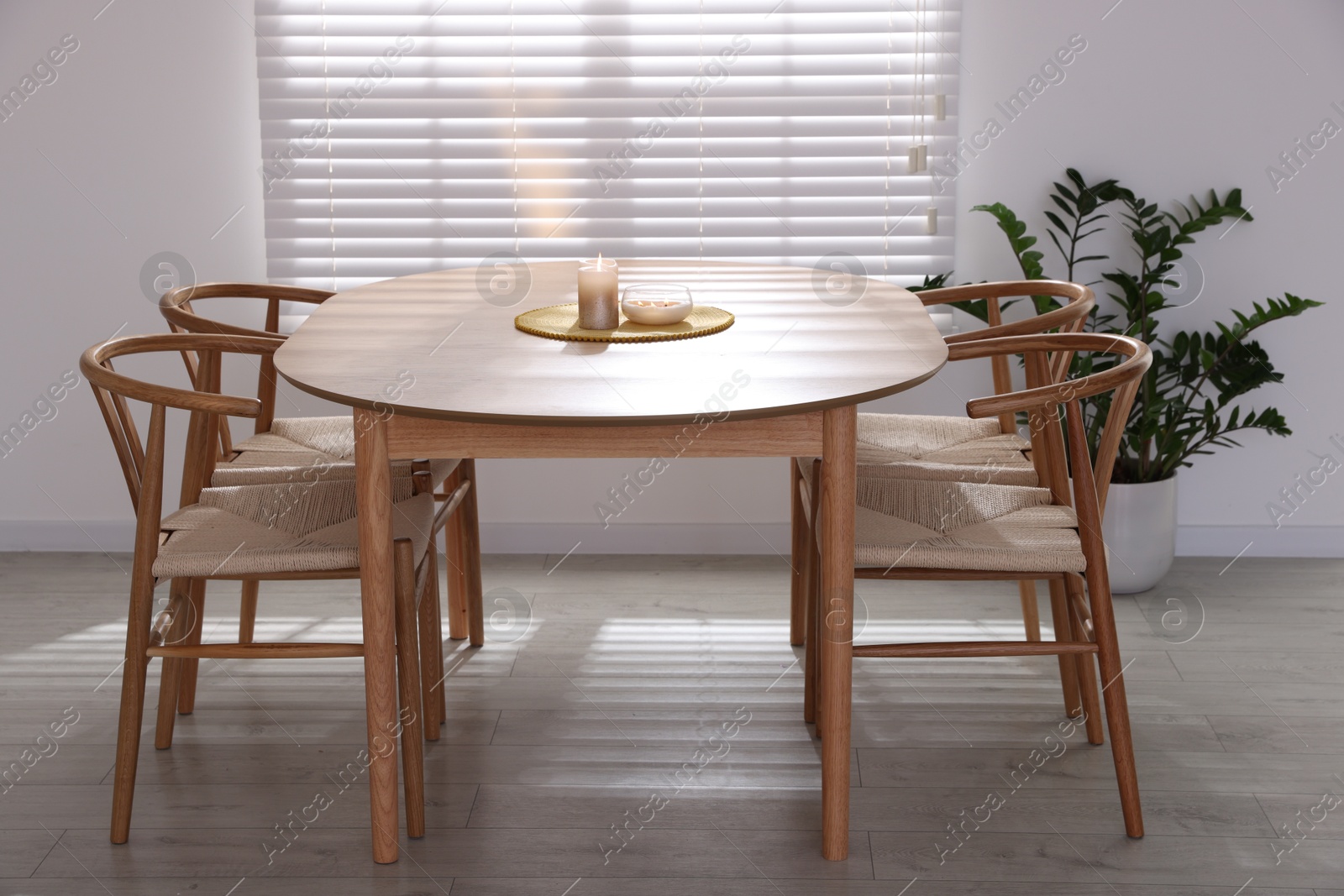 Photo of Stylish wooden table with chairs and decor indoors. Interior design