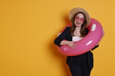 Photo of Businesswoman with inflatable ring, straw hat and sunglasses on orange background, space for text