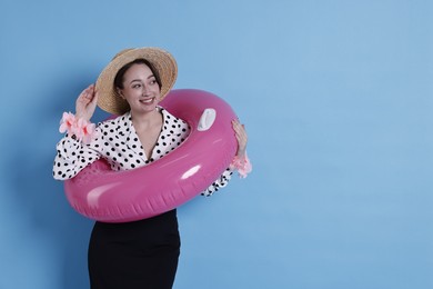 Photo of Businesswoman with inflatable ring, straw hat and flower bracelets on light blue background, space for text