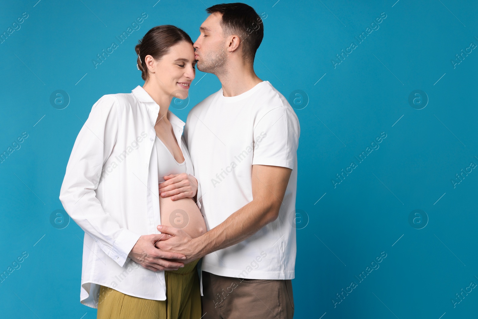 Photo of Pregnant woman and her husband on blue background