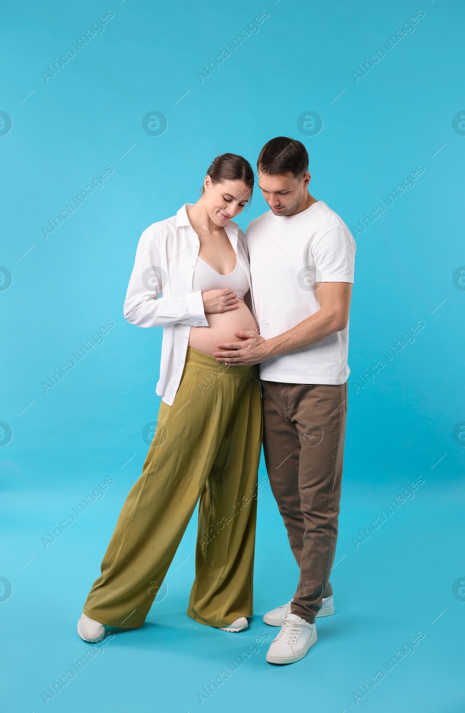 Photo of Pregnant woman and her husband on blue background