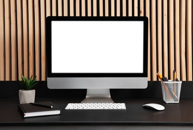 Photo of Comfortable workplace with modern computer on black table indoors