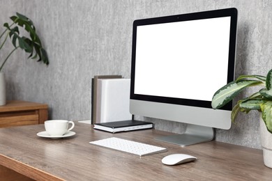 Photo of Comfortable workplace with modern computer on wooden table indoors