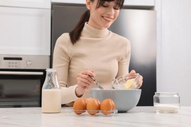 Photo of Making dough. Woman adding butter into bowl at white marble table, closeup