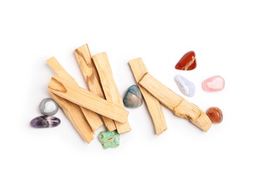 Photo of Palo santo sticks and gemstones isolated on white, top view