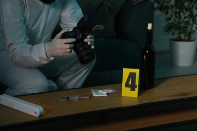 Photo of Forensic expert with camera taking photo of evidences at crime scene indoors, closeup