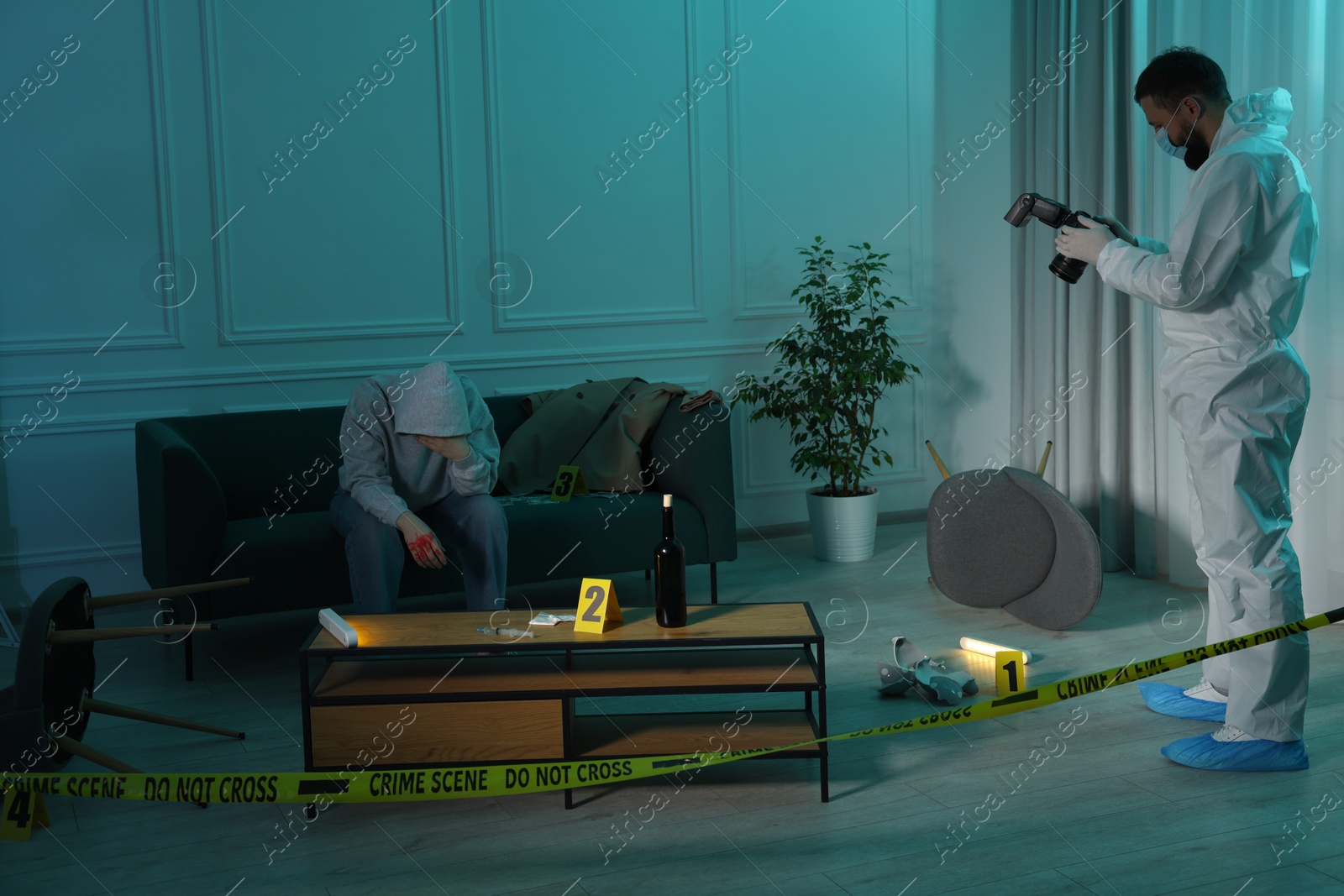 Photo of Forensic expert with camera working and victim at crime scene indoors