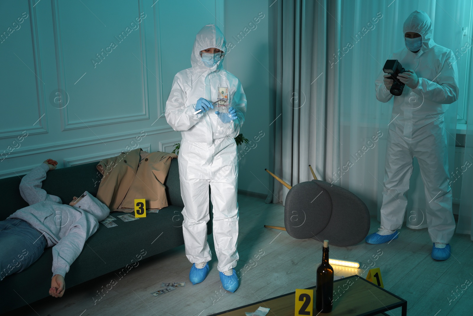 Photo of Forensic experts working at crime scene with dead woman's body indoors