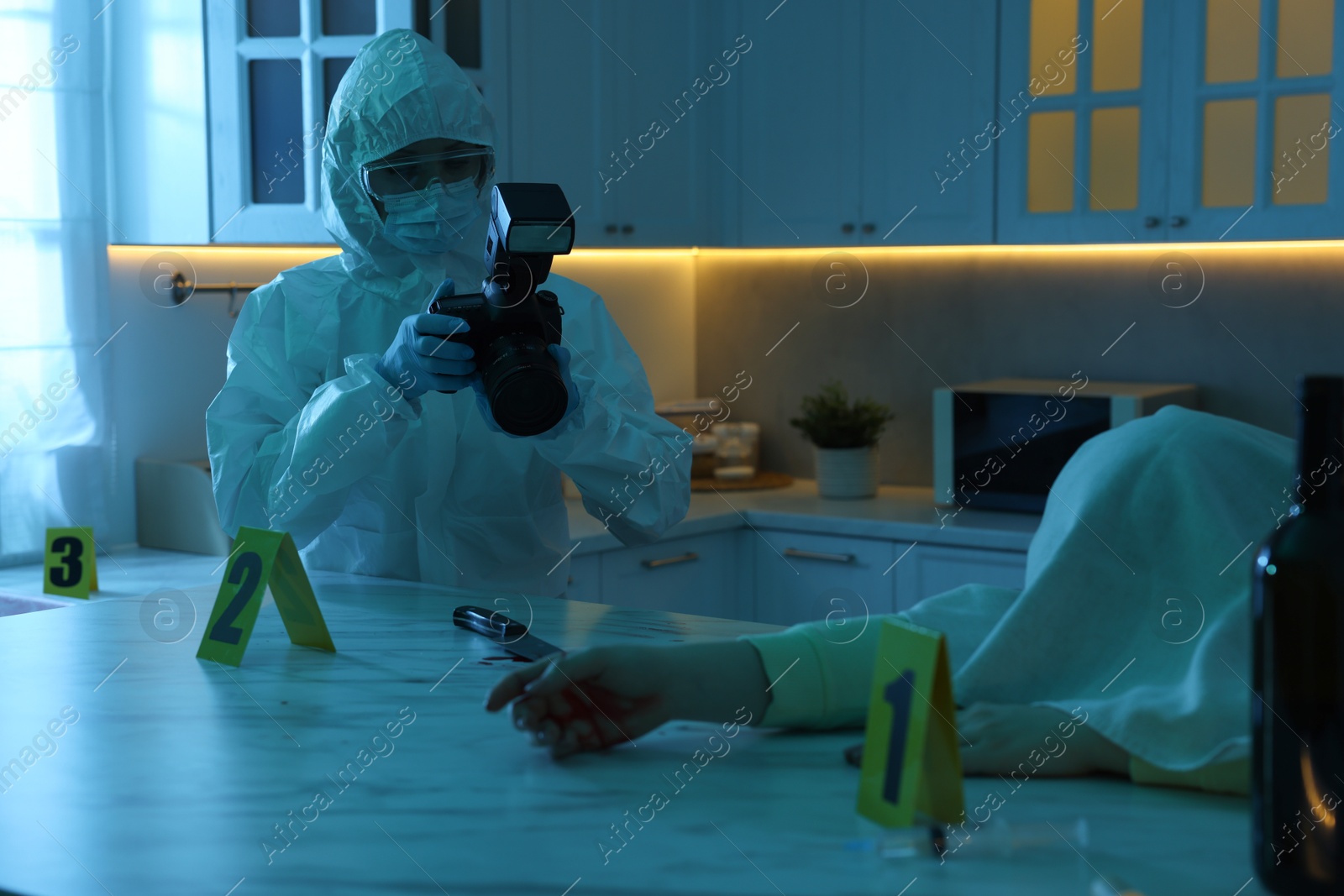 Photo of Forensic expert with camera working at crime scene and dead woman's body in dark room