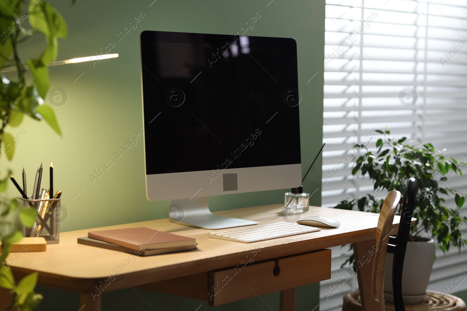 Comfortable workplace with computer and stationery on wooden desk in home office Photo of Comfortable workplace with computer and stationery on wooden desk in home office