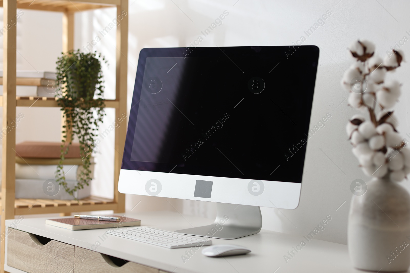 Home office. Comfortable workplace near white wall. Desk with computer and other furniture indoors Photo of Home office. Comfortable workplace near white wall. Desk with computer and other furniture indoors