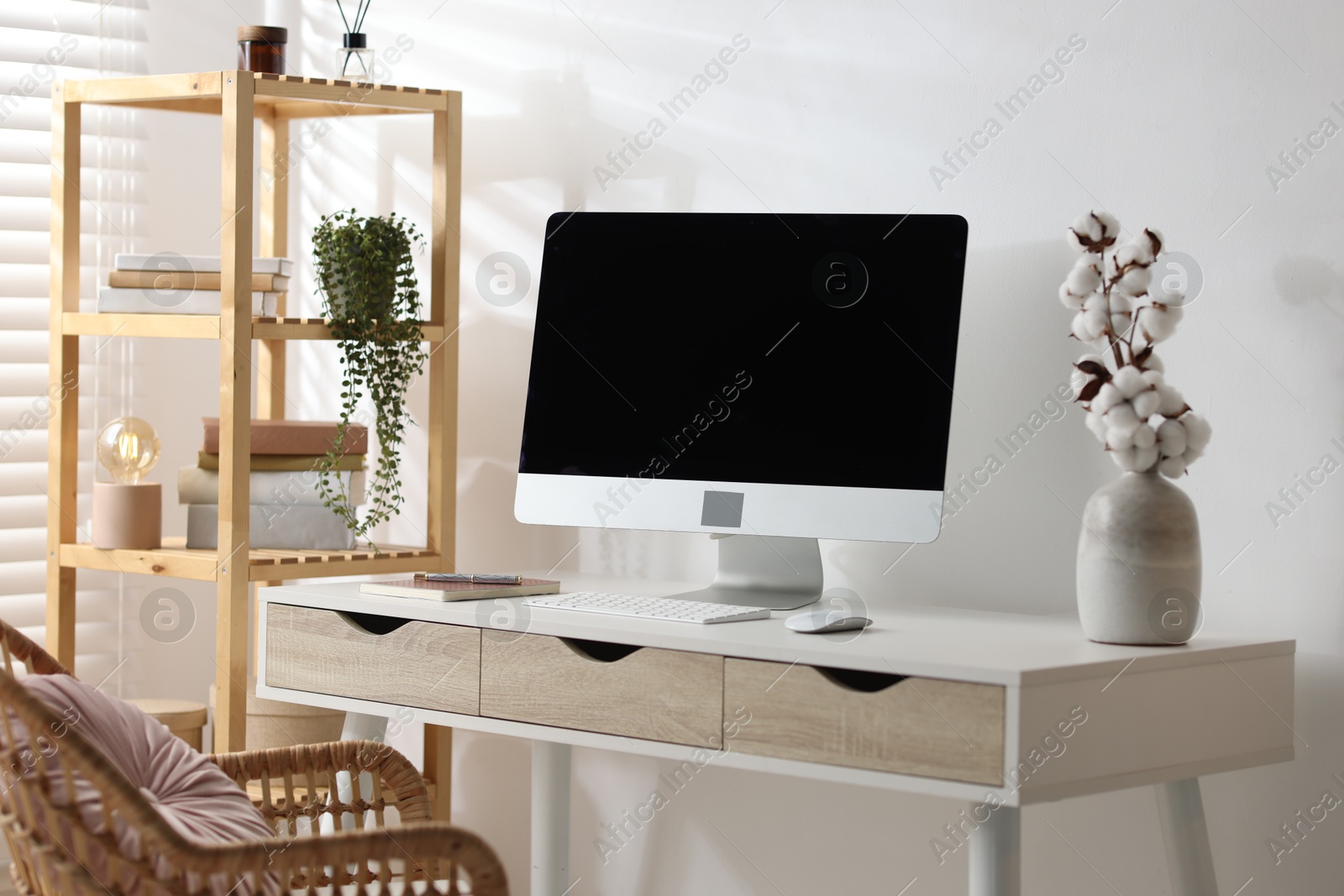 Photo of Home office. Comfortable workplace near white wall. Desk with computer and other furniture in room