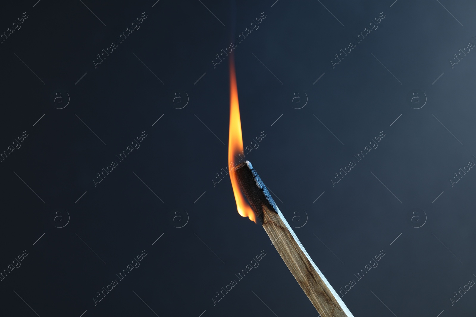 Photo of Burning palo santo stick against grey background, closeup