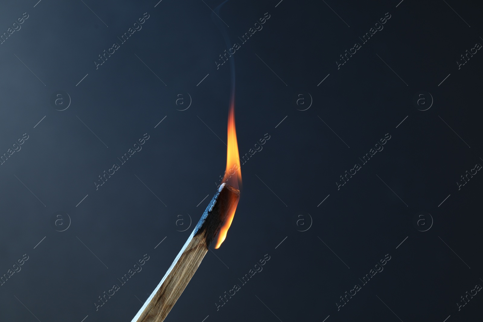 Photo of Burning palo santo stick against grey background, closeup