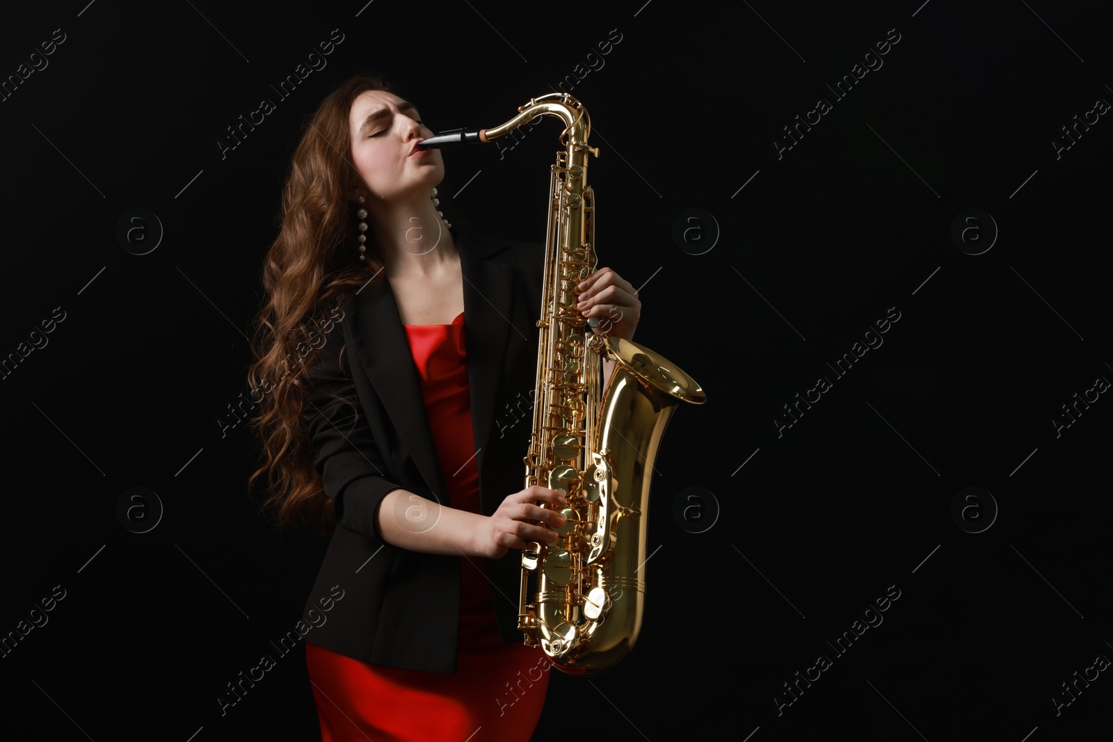 Photo of Professional musician playing saxophone on black background