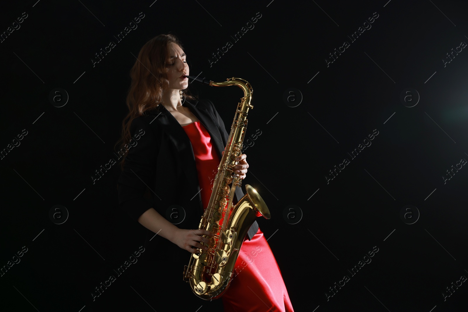 Photo of Professional musician playing saxophone on black background. Space for text