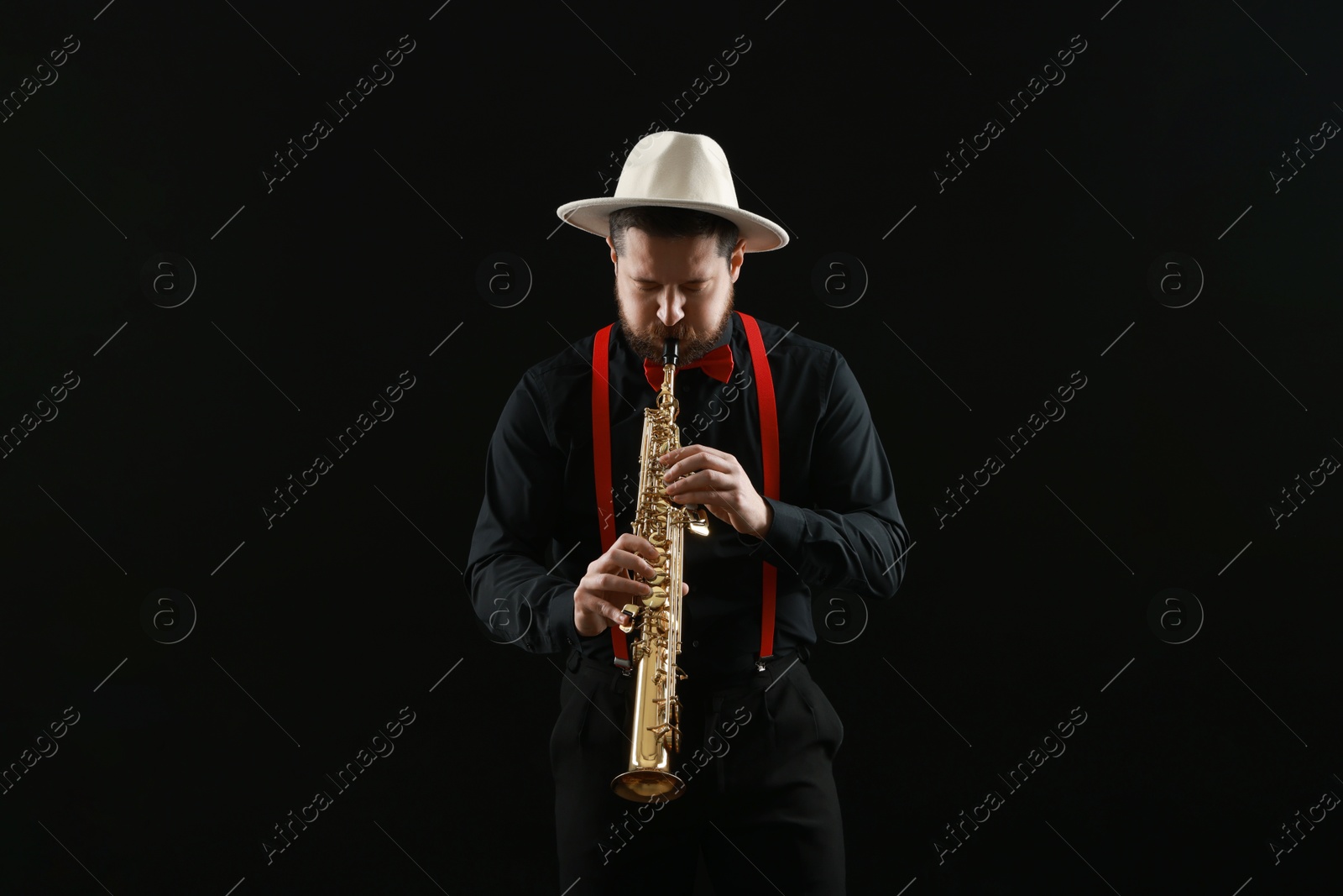 Photo of Professional musician playing soprano saxophone on black background