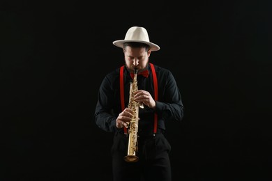 Photo of Professional musician playing soprano saxophone on black background