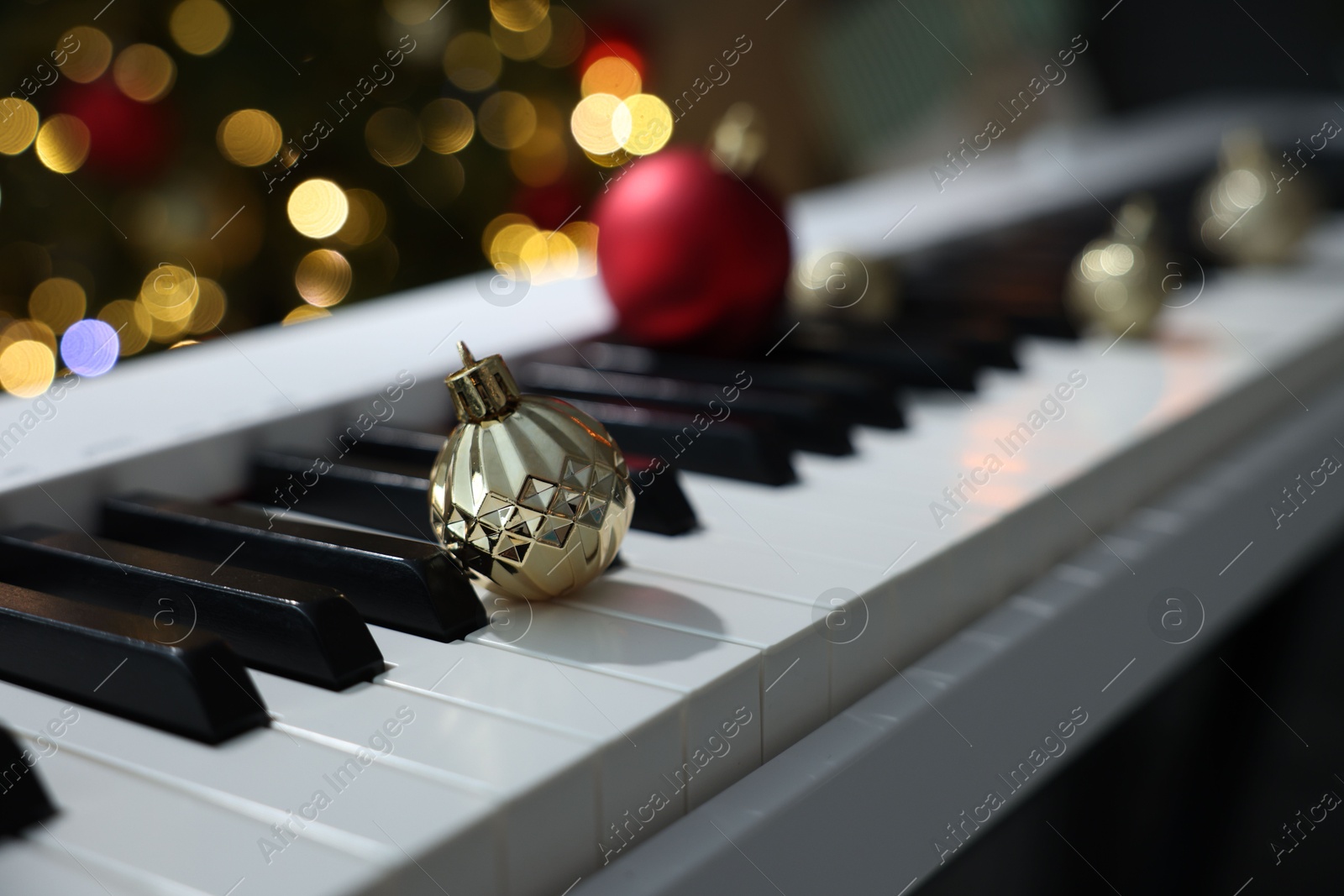 Christmas ornaments on electric piano against blurred lights, closeup. Bokeh effect Photo of Christmas ornaments on electric piano against blurred lights, closeup. Bokeh effect