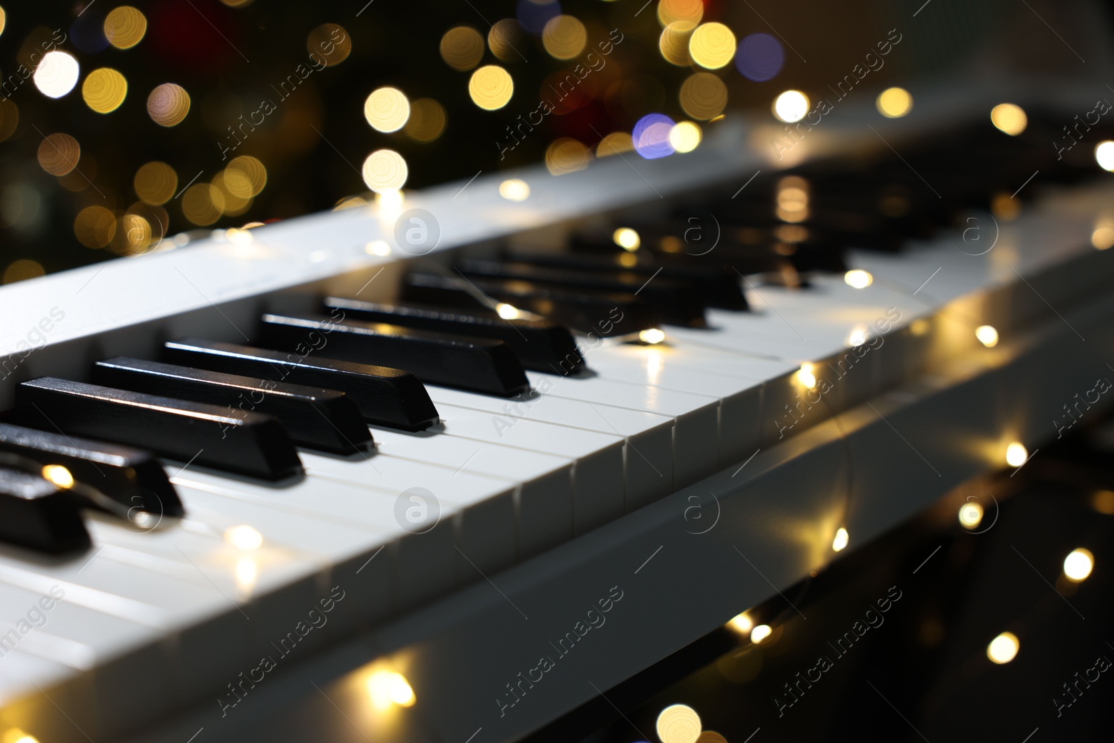 Electric piano against blurred lights, closeup. Bokeh effect Photo of Electric piano against blurred lights, closeup. Bokeh effect