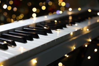 Photo of Electric piano against blurred lights, closeup. Bokeh effect