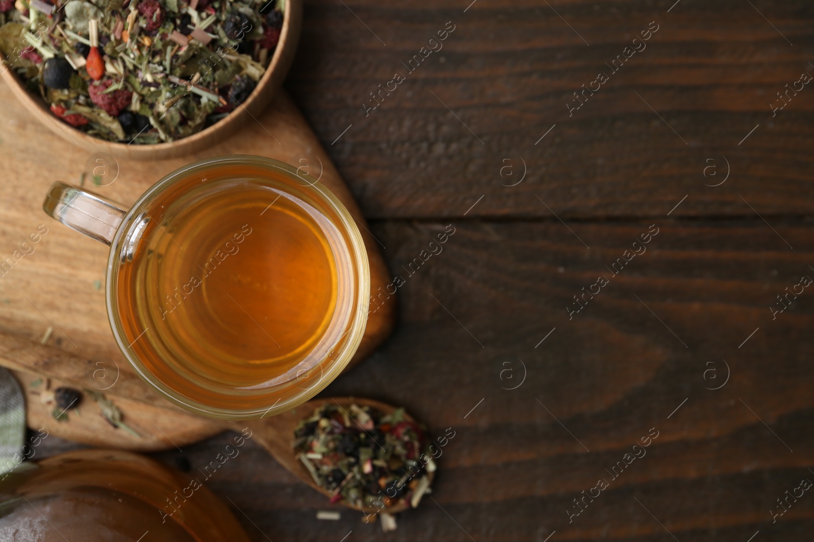 Photo of Delicious herbal tea and dry leaves on wooden table, flat lay. Space for text