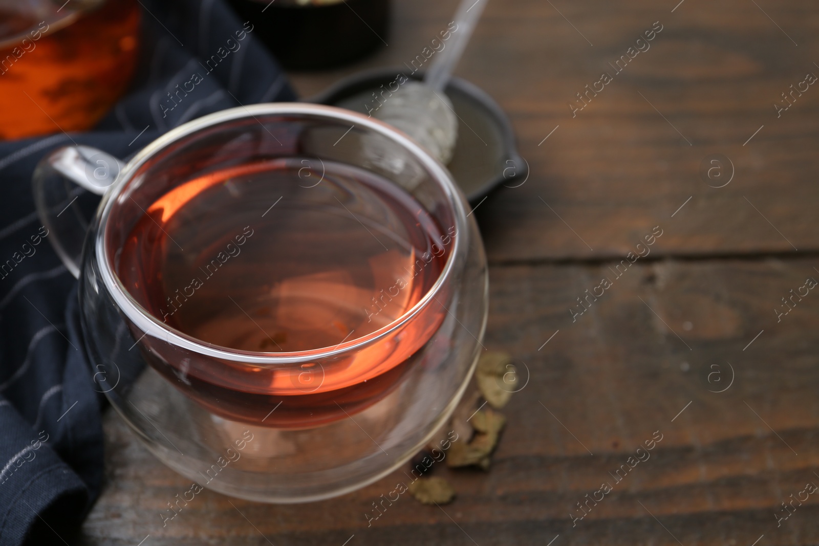 Photo of Delicious herbal tea and dry leaves on wooden table, closeup. Space for text