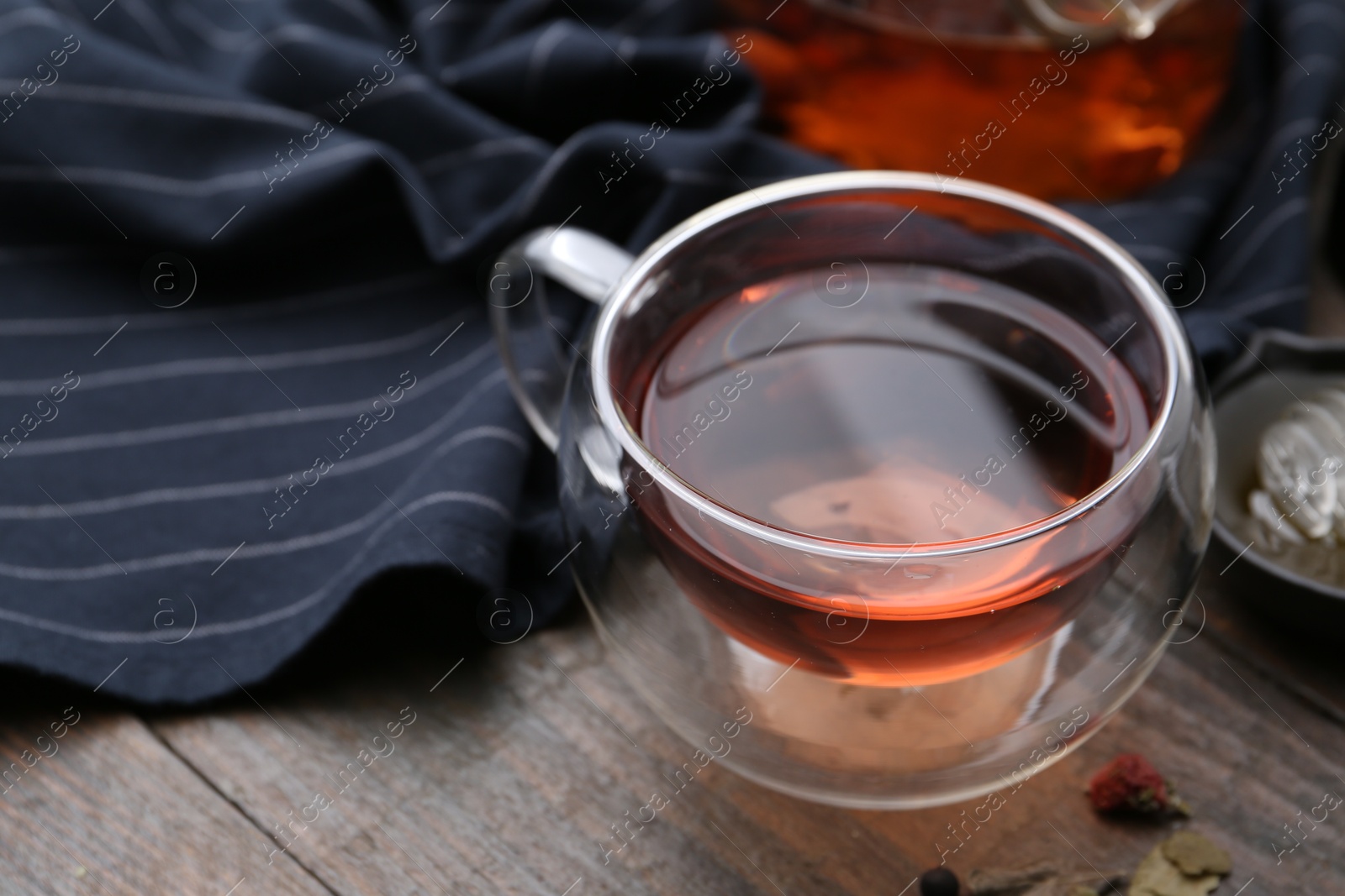 Photo of Delicious herbal tea and dry leaves on wooden table, closeup