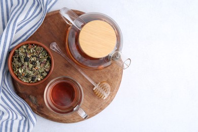 Photo of Delicious herbal tea, honey and dry leaves on white table, top view. Space for text