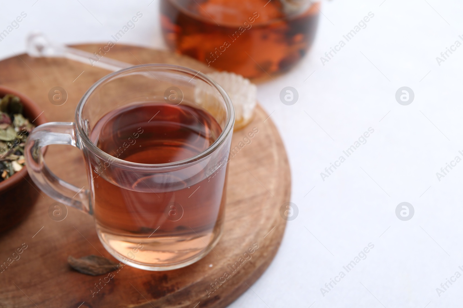 Photo of Delicious herbal tea with honey on white table. Space for text