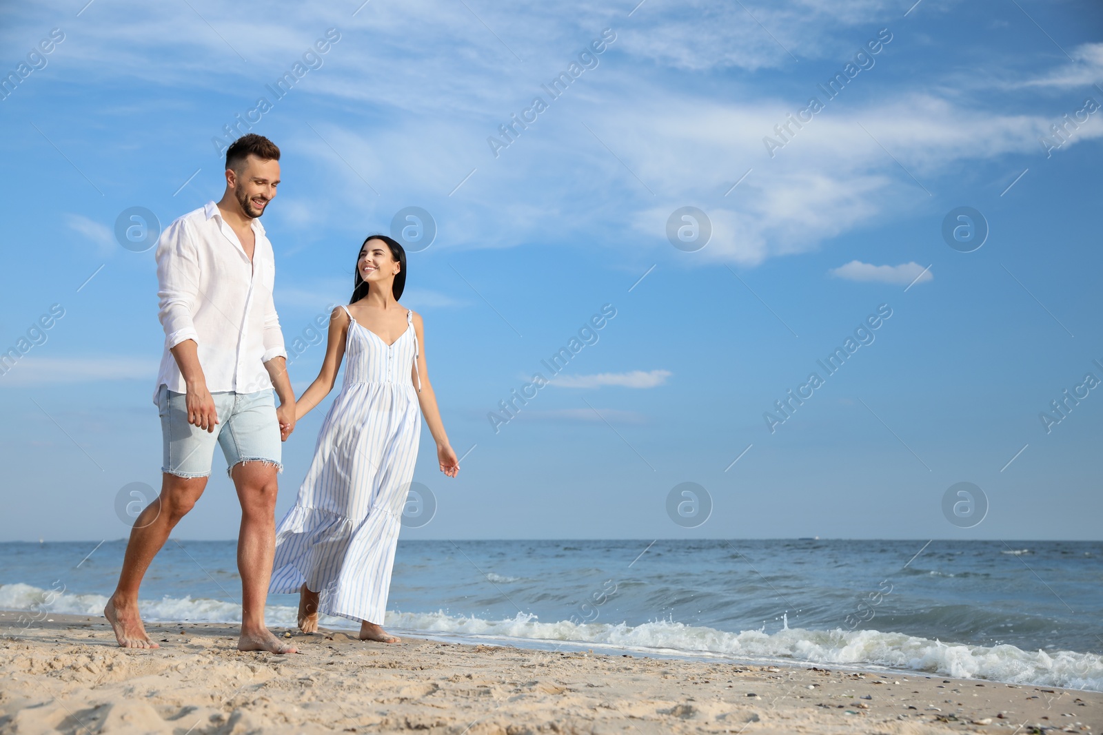 Photo of Happy young couple walking together on beach