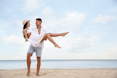 Photo of Lovely couple having fun on beautiful beach. Space for text