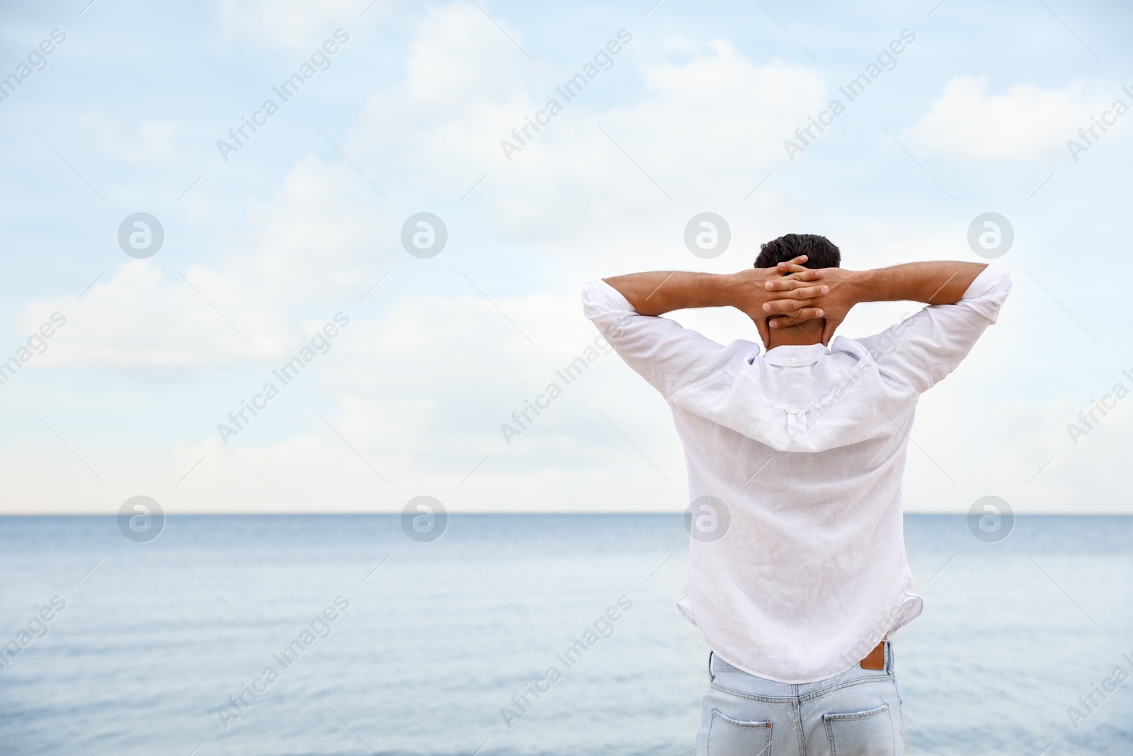 Photo of Man on beach near sea, back view. Space for text