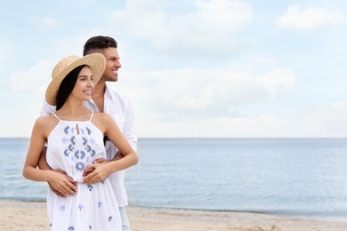 Photo of Lovely couple spending time together on beach. Space for text