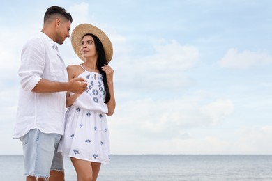 Photo of Lovely couple spending time together on beach. Space for text