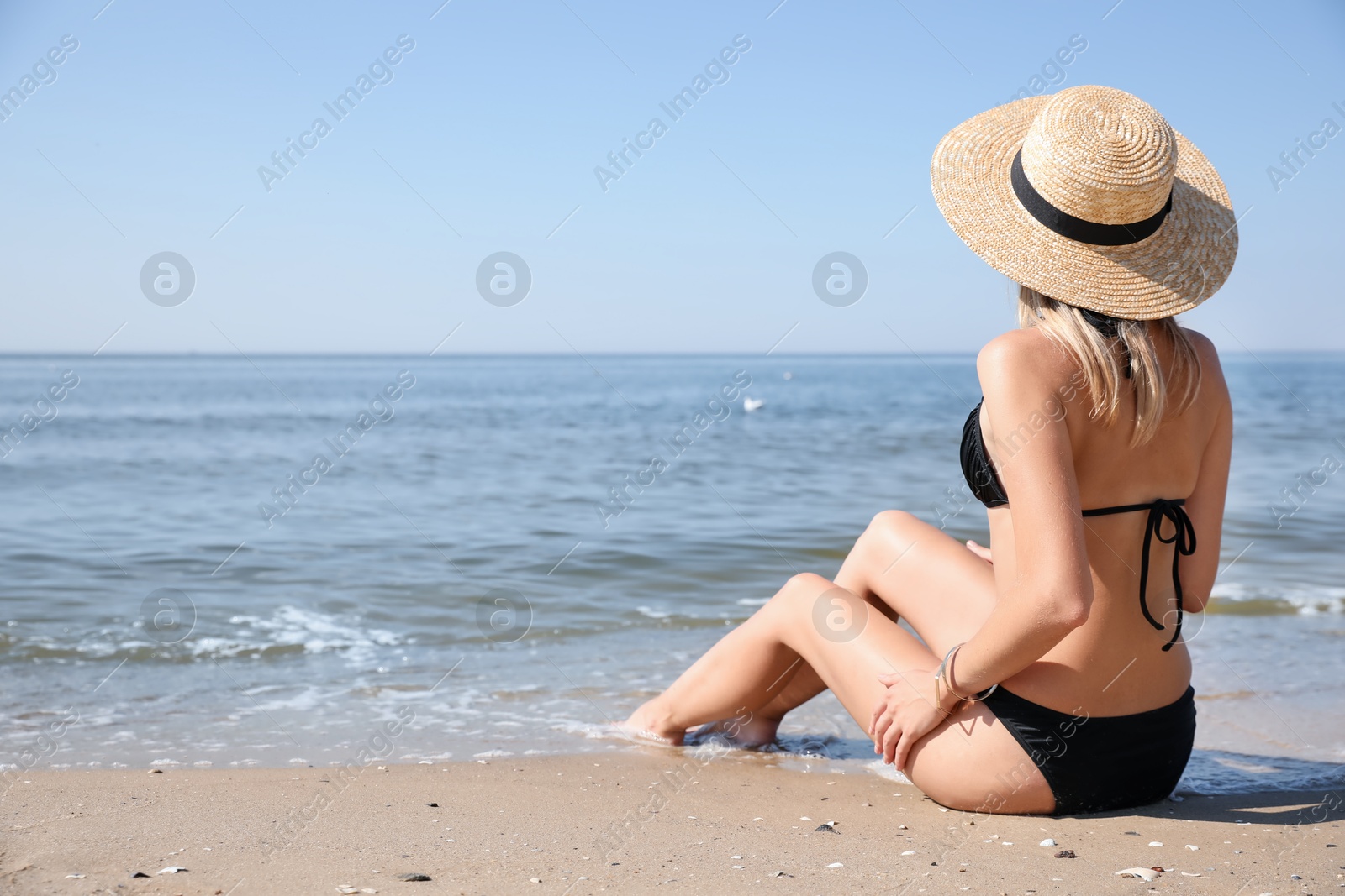 Photo of Young woman with beautiful body on beach. Space for text