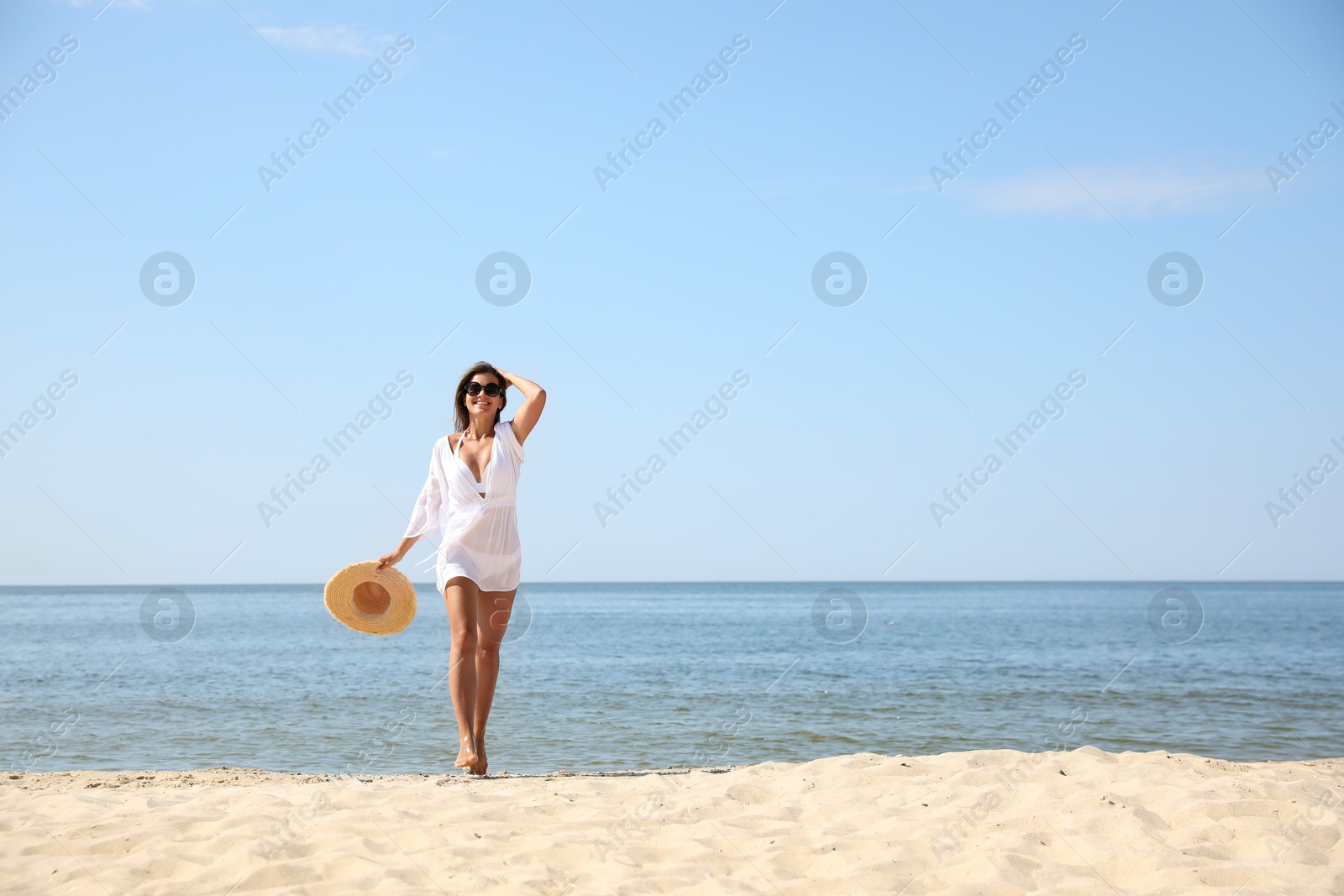 Photo of Young woman with beautiful body on sandy beach. Space for text