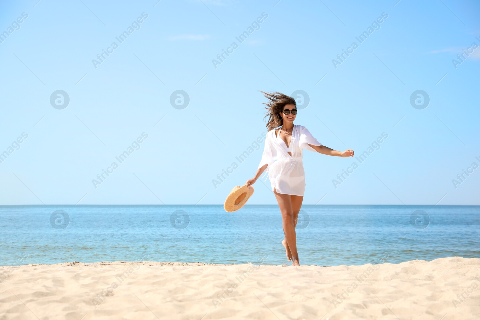 Photo of Young woman with beautiful body on sandy beach. Space for text