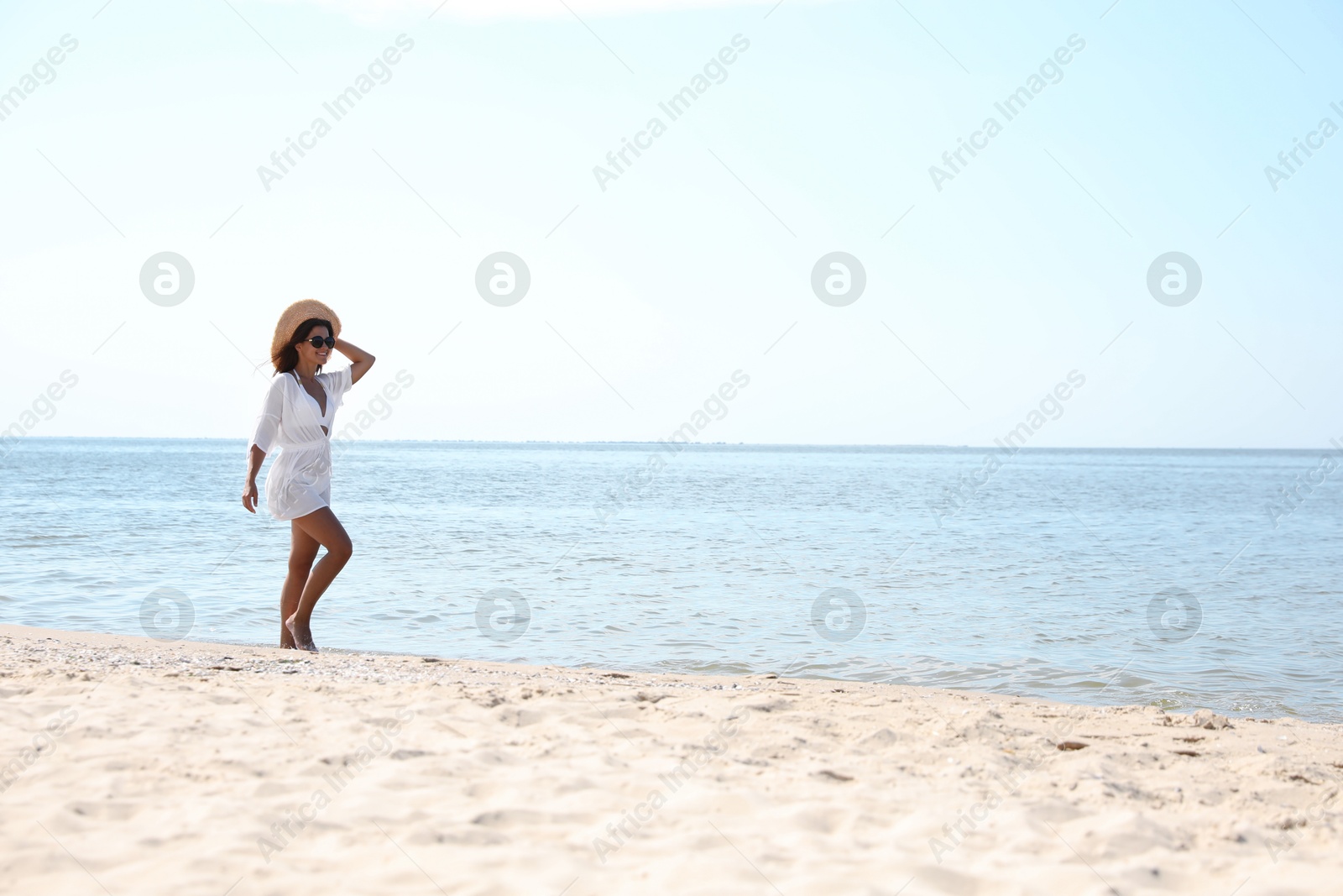 Photo of Young woman with beautiful body on sandy beach. Space for text