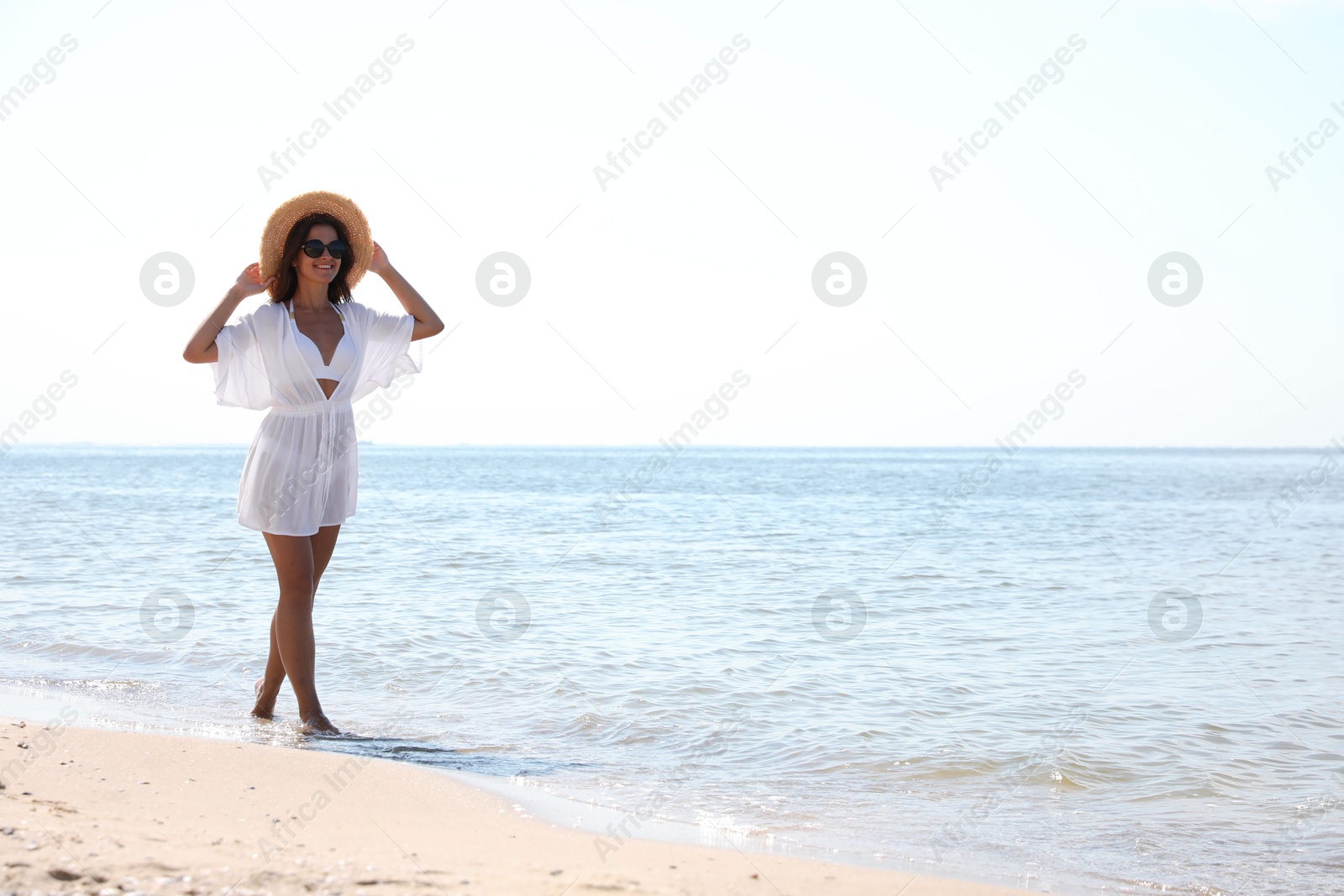 Photo of Young woman with beautiful body on sandy beach. Space for text