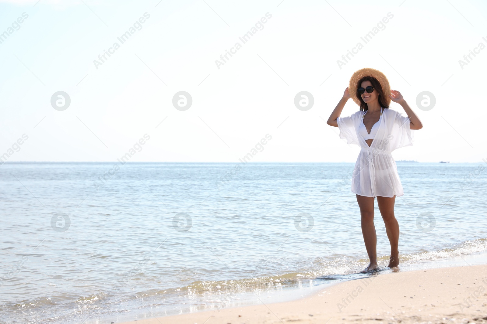 Photo of Young woman with beautiful body on sandy beach. Space for text