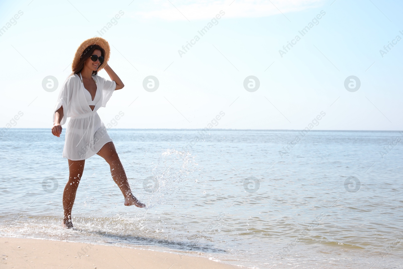 Photo of Young woman with beautiful body on sandy beach. Space for text